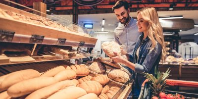 Dva lidé nakupují pečivo v supermarketu