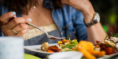 Žena jí jídlo v restauraci