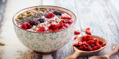 Miska snídaňové ovesné kaše s lesními plody, oříšky, semínky a plody goji