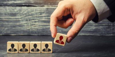 Ruka v obleku držící kostky s ikonou pracovníků