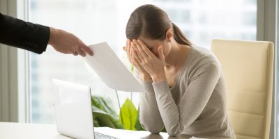 Žena pláče nad notebookem po obdržení výpovědi