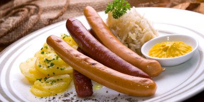 Talíř se třemi párky, hořčicí, zelím a bramborovým salátem