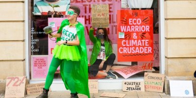 Aktivisté u a ve výloze řetězce H&M s pro-ekologickými transparenty