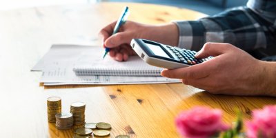 Muž přepočítává s kalkulačkou a zápisníkem