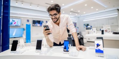 Muž si vybírá smartphone v kamenné prodejně