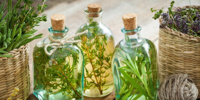 Trojice skleněných lahviček s bylinkami v oleji