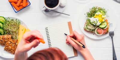 Žena si u jídla zapisuje do bloku