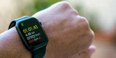 Detail zápěstí s chytrými hodinkami, které měří vzdálenost běhu, počet kroků a srdeční tep