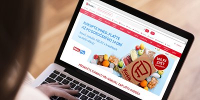 Žena si na notebooku prohlíží stránky Košík.cz, kde je reklama na nákup na splátky ve znění: Nakupte ihned, plaťte až po doručení do 14 dní