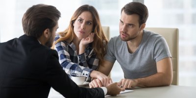 Mladý pár se dohaduje s prodejcem nad kupní smlouvou