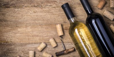 Lahve bílého a červeného vína, vývrtka, korkové zátky