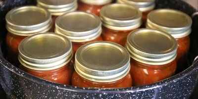 Plné zavařovací sklenice nachystané v hrnci