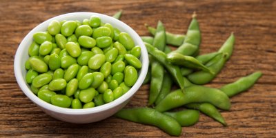 Boby edamame v mističce, vedle leží lusky edamame