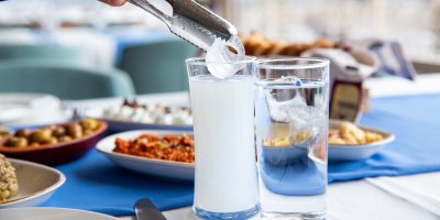 Příprava dvou sklenic koktejlu s likérem Raki a ledem