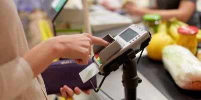 Žena platí kartou v supermarketu 