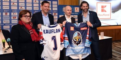 Jaromír Jágr a další tři lidé na tiskové konferenci drží hokejové dresy, na jednom je nápis Kaufland
