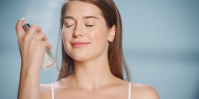 Žena si stříká pleťovou vodu na obličej