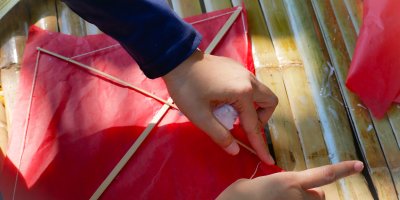 Člověk slepuje papírového draka