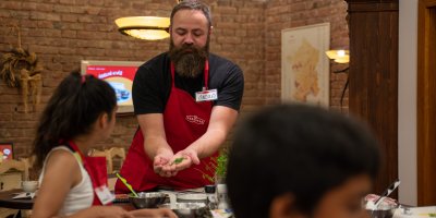 Skupina dětí vaří s kuchařem s výrobky značky Podravka 