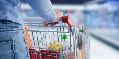 Žena tlačí plný nákupní vozík