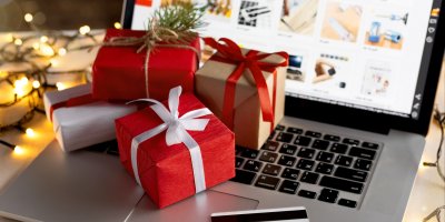 Hromádka vánočních dárků na otevřeném notebooku s e-shopem