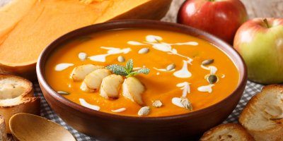 Dýňový krém ozdobený smetanou, semínky a jablky