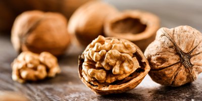 Půlka vlašského ořechu ve skořápce, celý vlašský ořech ve skořápce