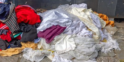 Oblečení na hromadě u popelnice