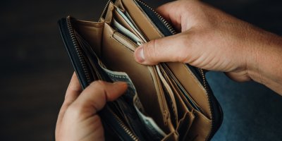 Muž otevírá poloprázdnou peněženku