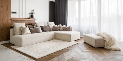 Obývací pokoj s bílým gaučem a kobercem