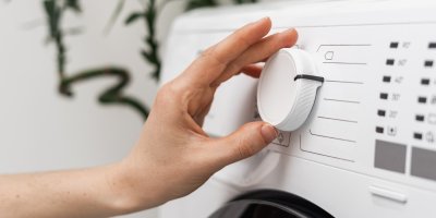 Člověk otáčí kolečkem na pračce