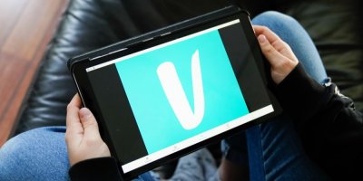 Muž drží tablet a má tam otevřenou aplikaci Vinted