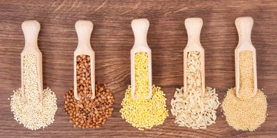 Různé druhy krup v dřevěných naběračkách na stole