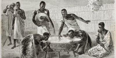 Historická, černobílá kresba afrických domorodců pijících pivo z kádě