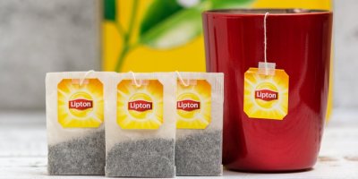 Tři čajové sáčky Lipton, hrnek, ve kterém se louhuje čaj Lipton