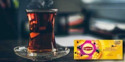 Čaj a krabička čaje Lipton s příchutí mango a černý rybíz na stole