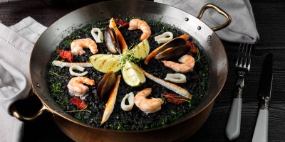 Paella z černé rýže, krevet a dalších mořských plodů