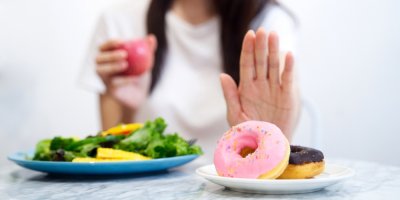 Žena se zdravým a nezdravým jídlem