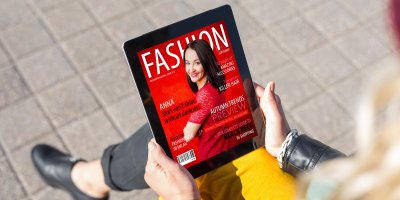 Žena si čte lifestyle časopis na tabletu