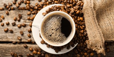 Šálek kávy, rozsypaná zrnková káva