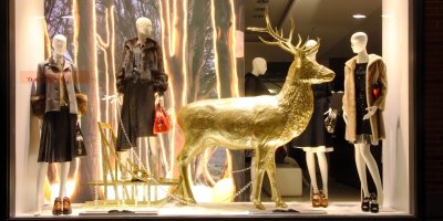 Vánočně vyzdobená výloha obchodu, čtyři figuríny a zlatá socha soba