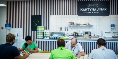 Lidé sedí v kantýně u stolu