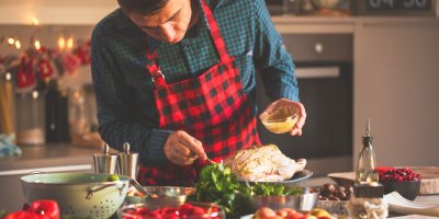 Muž v zástěře připravuje pečenou husu