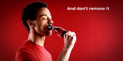 Muž pije nápoj Coca-Cola Zero z lahve s neoddělitelným víčkem