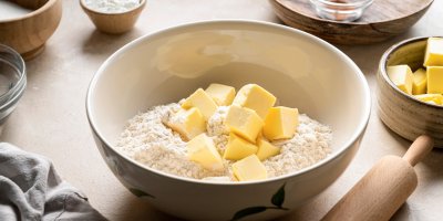 Nakrájené máslo v misce mouky
