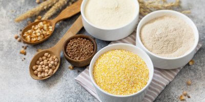 Tři druhy mouky v miskách: pohanková, kukuřičná a cizrnová