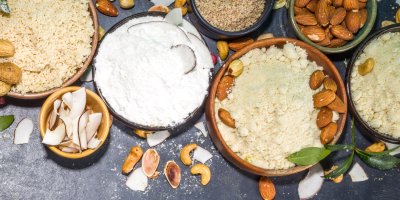 Různé druhy mouky v miskách, včetně kokosové a mandlové