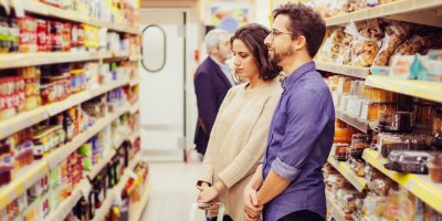 Pár vybírá zboží z regálu v obchodě