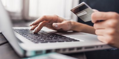 Ruce s kreditní kartou u notebooku