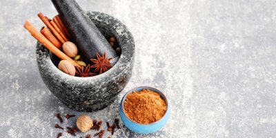 V hmoždíři je skořice, badyán, hřebíček a muškátový ořech, vedle je mistička s perníkovým kořením